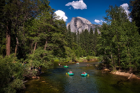 group of people on inflatable boat surrounded by trees thumbnail