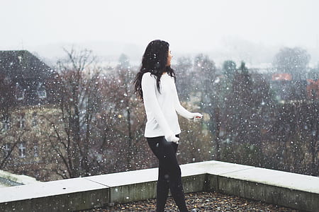 woman standing on roof top during snow thumbnail