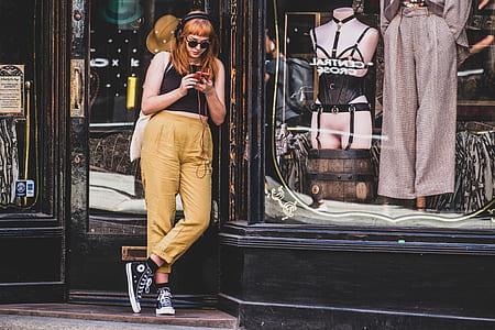 woman standing in front of dress shop while wearing headphones thumbnail