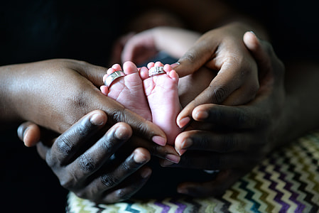 Hands holding Baby Feet with rings thumbnail