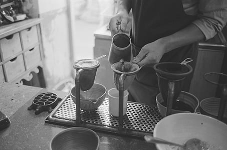 grayscale photo of person pouring pitcher on mug thumbnail