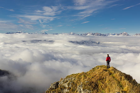 man wearing red jacket on rock formation thumbnail