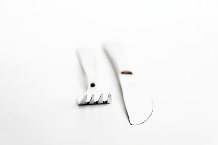 close-up photo of gray stainless steel fork and butter knife on white surface thumbnail