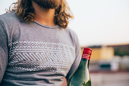A bearded caucasian man wearing T-shirt holding an Italian bottle thumbnail