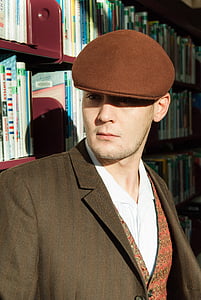 man leaning on wooden bookshelf thumbnail