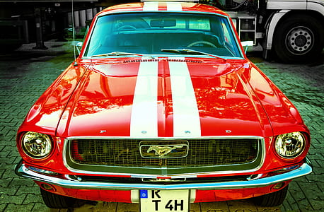 red and white Ford Mustang parked near white truck thumbnail