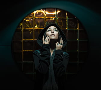 woman in black hoodie near brown ceramic tile wall thumbnail