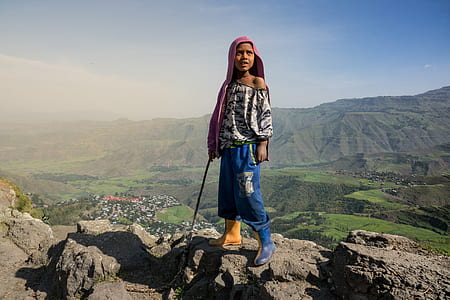 woman standing on gray rock formation thumbnail