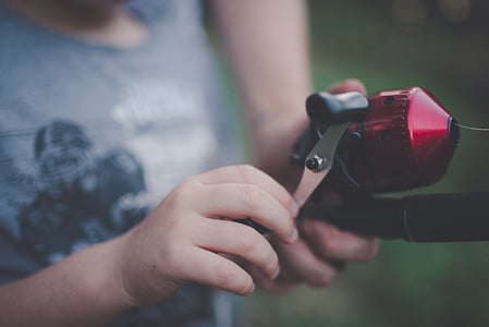 person in grey top reeling red and black fishing rod thumbnail