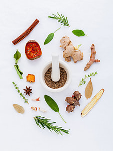 white ceramic mortar and pestle between variety of spices thumbnail
