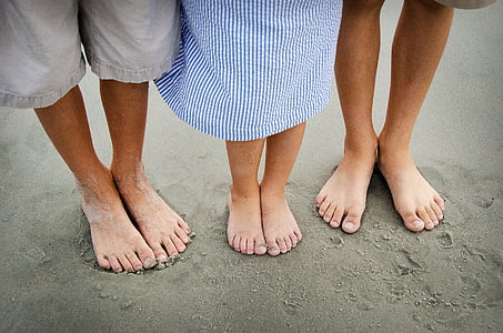 three people standing on grey sand thumbnail