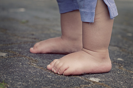 kid wearing blue pants standing on concrete floor thumbnail