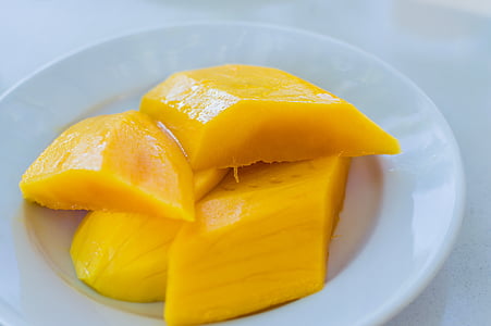 sliced mango fruit on white plate thumbnail