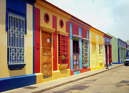 yellow, red, blue, and green 1-storey house under white clouds thumbnail