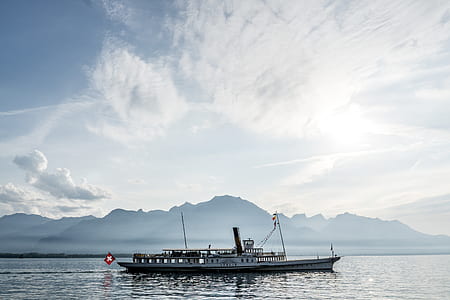white and brown boat under cloudy sky during daytime thumbnail