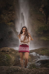 woman standing near waterfalls thumbnail