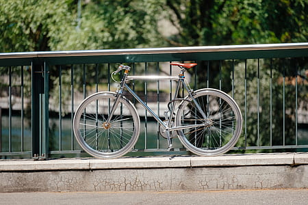 gray road bike beside gray metal railing during daytime thumbnail