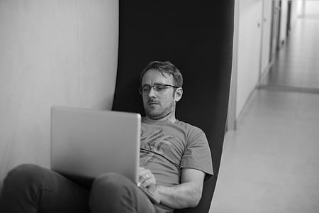 man sitting on chair while using laptop thumbnail