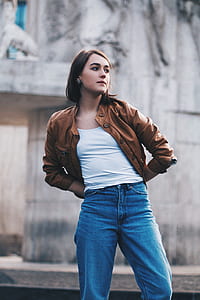woman wearing brown button-up leather jacket and blue denim jeans thumbnail
