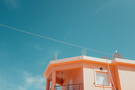 orange concrete house under blue sky thumbnail