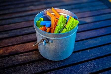 close up photography of assorted-color plastic clips inside gray stainless steel bucket thumbnail