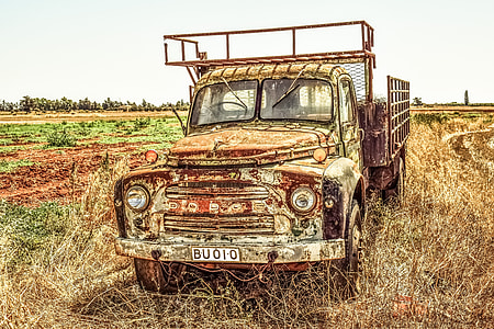 closeup photo of rusted pickup truck park on brown grass field thumbnail