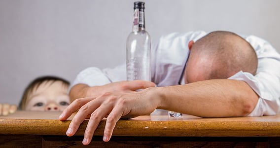 man holding a bottle sitting near the boy thumbnail