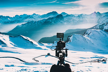 black professional video camera on snow covered mountain thumbnail