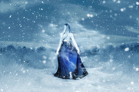 woman in blue dress surrounded by snowy trees photo thumbnail