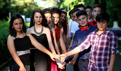 girls and boys holdings hand near trees during daytime thumbnail