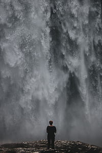 person standing in front of waterfalls thumbnail