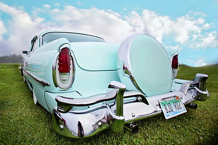 photo of vintage teal car parked on green grass field thumbnail