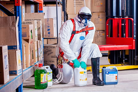 man wearing coveralls holding white bottle thumbnail