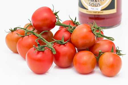 red tomatoes near black labeled bottle thumbnail