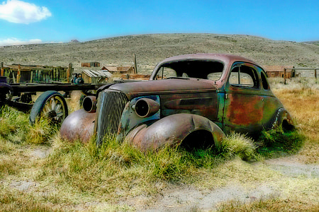 rusty Beetle car parked in middle of grass field thumbnail