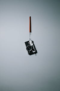 black and grey SLR camera hanging on wall thumbnail