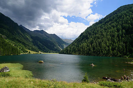 body of water beside mountain thumbnail