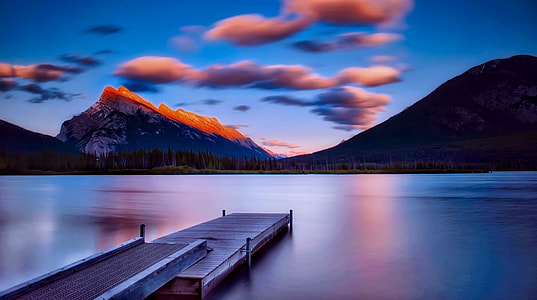 photo of lake dock with calm water  under gray clouds thumbnail
