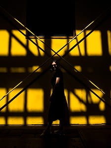 photo of woman standing beside yellow wall thumbnail
