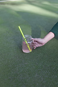 person holding mason jar with straw thumbnail