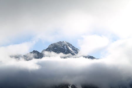snow-covered mountain surrounded by clouds during daytime thumbnail