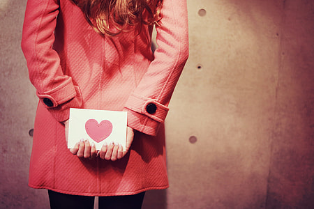 woman wearing pink coat holding back her love letter card thumbnail