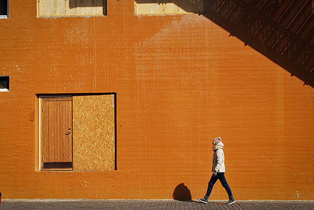 person walking near brown building thumbnail
