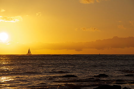 silhouette of boat on body of water in golden hour background thumbnail