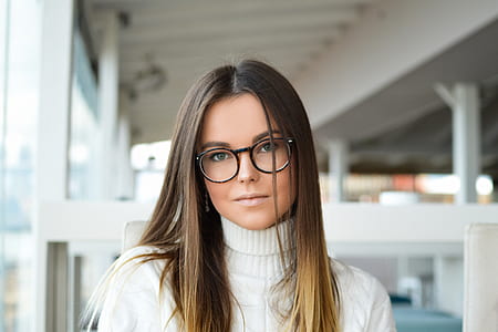 woman wearing white turtle-neck top taking selfier thumbnail