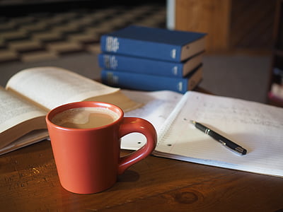 cup of coffee near click pen and notebook on table thumbnail