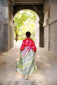 walking woman wearing red and grey traditional dress thumbnail