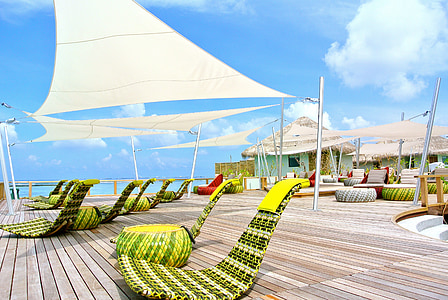 green woven chairs on brown wooden dock thumbnail