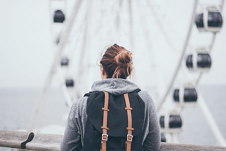 selective focus photography of woman standing near ferris wheel thumbnail