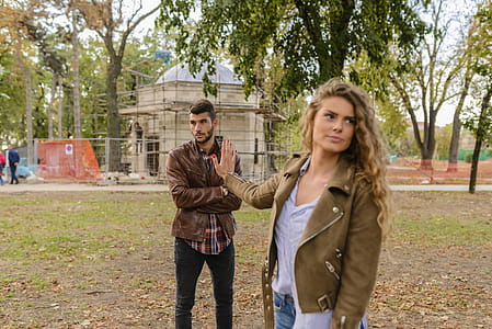 Man and Woman in Brown Leather Coat Standing on Brown Soil thumbnail